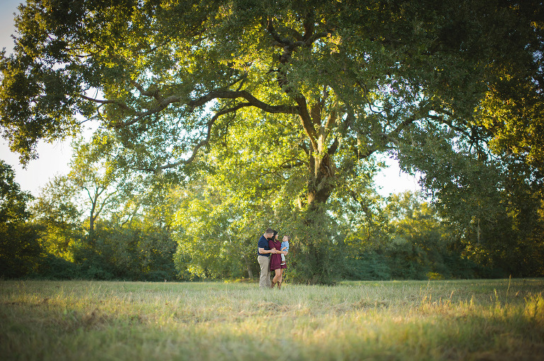 North Houston Family Photographer - Mom and dad holding their baby under an Oak Tree for their Houston Family Session. 